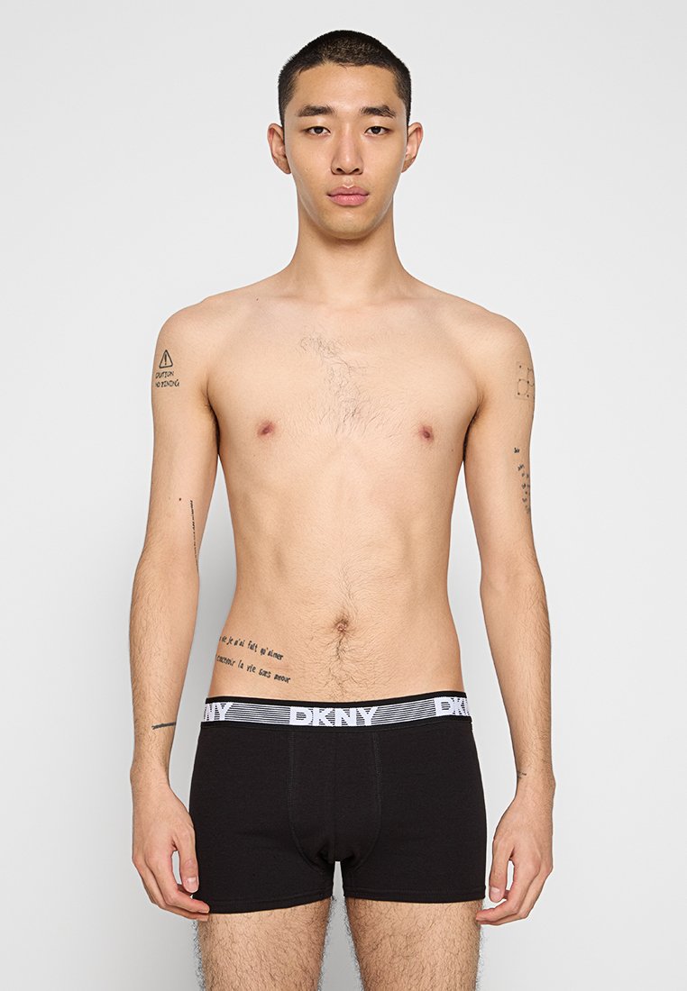 Czarne bokserki DKNY z białą bandą z logo. Tkanina wygląda na gładką, dopasowany krój, z wyprofilowaną formą dla wygody i wsparcia.