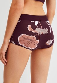 Bordeaux shorts met een bloemenpatroon en een zachte tailleband; heeft lichtroze en witte bloemillustraties op een gestructureerde stof.