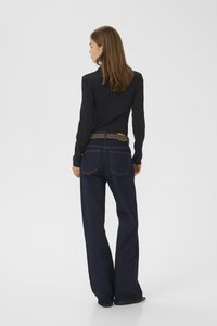 Black long-sleeve top, blue wide-leg jeans with a brown and gray belt. Plain texture with visible stitching and pocket details.