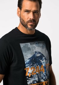 Černé bavlněné tričko s grafikou hory a textem "Jižní Dakota 7 244 FT" v oranžových a šedých tónech.