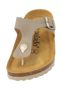 Tan en beige sandaal met een kurken voetbed, verstelbare gesp en een gladde textuur bovenstuk. Heeft een teenpost ontwerp.