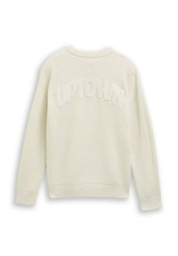 Pull en crème texturé avec un design à côtes, col rond, et le mot "UPTOWN" en lettres en relief de couleur crème au dos.