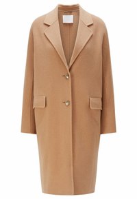 Cappotto di lana beige con colletto a revers, chiusura a due bottoni e tasche frontali. Tessuto strutturato e design oversized a taglio dritto.