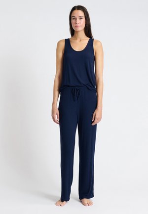 Ensemble de débardeur et pantalon en tissu doux bleu marine avec une coupe ample. Les pantalons sont dotés d'une taille avec cordon de serrage réglable. Design minimaliste, sans motifs visibles.