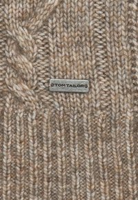Gebreide trui stof in beige en bruine tinten met een textuur ribbelpatroon en een klein zilveren label met de tekst "TOM TAILOR."