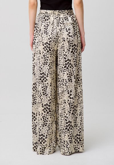 Pantalones de pierna ancha en tejido beige claro con un patrón de estampado de leopardo negro, cintura elástica y detalle de bolsillo trasero.