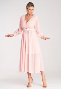 Sukienka midi w stylu fit-and-flare z jasnoróżowego chiffon, z dekoltem w kształcie litery V, plisowanym topem, długimi rękawami i paskiem w talii.