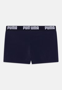 Tamno plave bokserice od glatke tkanine, s crnim pojasom i bijelim natpisom "PUMA" duž gornjeg ruba.