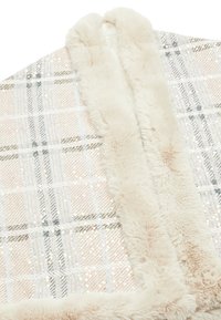 Kostkovaná deka s kovovým leskem a měkkým umělým kožichem. Barvy zahrnují světlou růžovou, krémovou a jemné stříbrné akcenty.