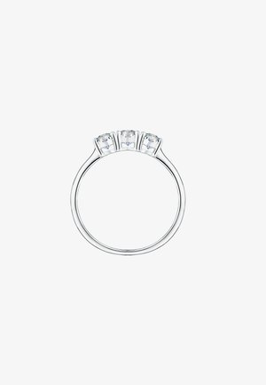 Anello tre pietre con una fascia in argento lucido e tre pietre trasparenti tagliate rotonde montate in griffe. Design semplice ed elegante.