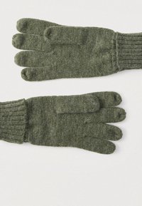 Zelene pletene rokavice z rebrastimi manšetami. Brez prstov, z ločenimi petimi prsti. Mehka tekstura in enakomerni šivi povsod.