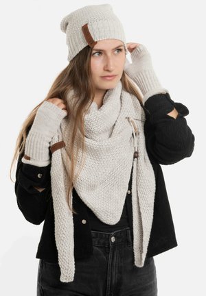 Lichtgrijze gebreide beanie, bijpassende sjaal en vingerloze handschoenen met leren accenten. Gelaagd ribbelpatroon en gezellige textuur.