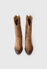 Ein Paar hellbraune Wildleder-Cowboystiefel mit gestickten Dekormustern, spitzen Zehen und seitlichen Reißverschlüssen auf einem weißen Hintergrund.