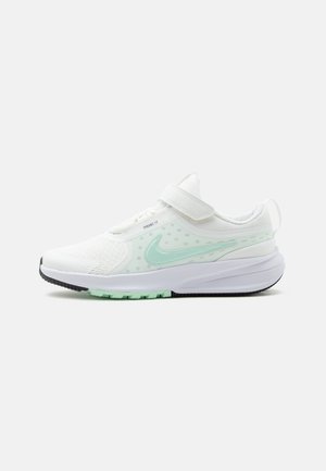 Chaussure de course blanche Nike avec un swoosh vert clair, empeigne en mesh, semelle amortie et bride Velcro réglable.