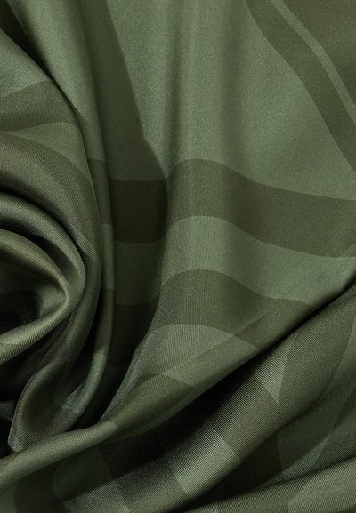 Λείο σκούρο πράσινο ύφασμα με διακριτικές γυαλιστερές ρίγες και μαλακές πτυχώσεις που δημιουργούν απαλές σκιές και ανταύγειες.