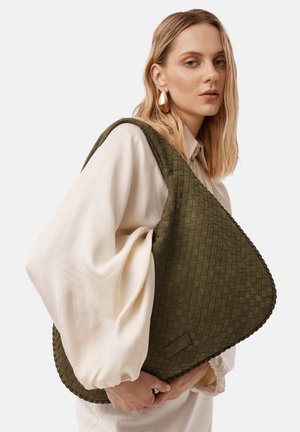 Green woven shoulder bag with a triangular shape, textured surface, and a smooth edge. The bag has minimal hardware detailing and a subtle logo.