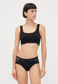 Black bra with a scoop neckline and lace trim, paired with black panties featuring lace accents. Smooth texture, simple design.