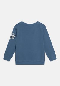 Niebieska bluza wykonana z miękkiego materiału, z długimi rękawami i okrągłym dekoltem. Na lewym rękawie znajduje się tekst "PUPILE W ZABAWIE!" w kolorze białym.