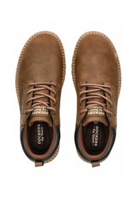 Chaussures en cuir marron avec un bout rond, des lacets plats et des accents cousus. Présentent un talon noir et un logo sur la languette. Semelle intérieure texturée.