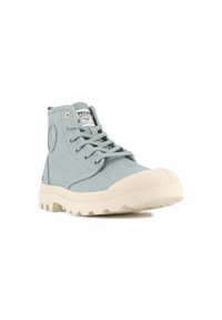 Sneakers high-top azzurri realizzati in tela con una finitura testurizzata e suola in gomma beige. Presentano un patch rotondo con logo e occhielli a contrasto.