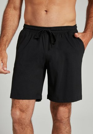 Black shorts made of soft fabric with an elastic waistband, drawstring, and side pockets. Simple design with a straight cut and no patterns.