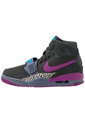 Sort højt sneakers med lilla Nike-swoosh, lilla og grå sål, mønstret detalje nær mellemsålen og blå strop over snørebåndene.