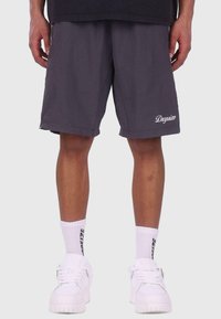 Grå shorts lavet af letvægtsstof med en afslappet pasform, der har et broderet "Dogsize"-logo. Parret med hvide sneakers og sokker.