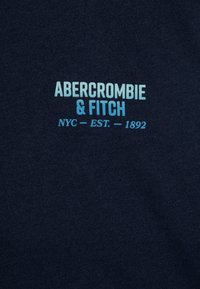 Mørkeblå sweatshirt med et lysblåt trykt logo: "ABERCROMBIE & FITCH" med "NYC - EST. 1892." Glat tekstur, afslappet design.