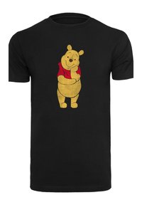 Svart t-skjorte med en vintage-lignende illustrasjon av en gul bjørn med en rød skjorte, plassert sentralt med et leken uttrykk.