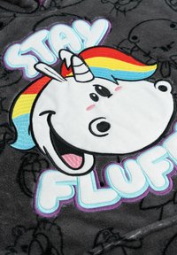 Tessuto in pile grigio con un ricamo di un unicorno cartone animato con criniera arcobaleno e il testo "STAY FLUFF" in colori pastello. Texture morbida.