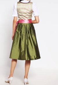 Perinteinen puku, jossa on istuva, kuviollinen yläosa vaaleanvihreänä vaaleanpunaisella satiinivyöllä, sekä täysipituinen, poimuinen tummanvihreä hame. Valkoiset kengät.