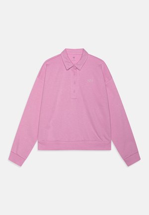Polo rose à manches longues avec col, patte de boutonnage à trois boutons et petit logo blanc sur le côté gauche de la poitrine, posé à plat sur fond blanc.