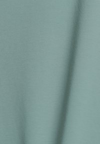 Tissu uni à texture douce de couleur vert sauge atténuée avec des plis subtils et un motif tricoté régulier.