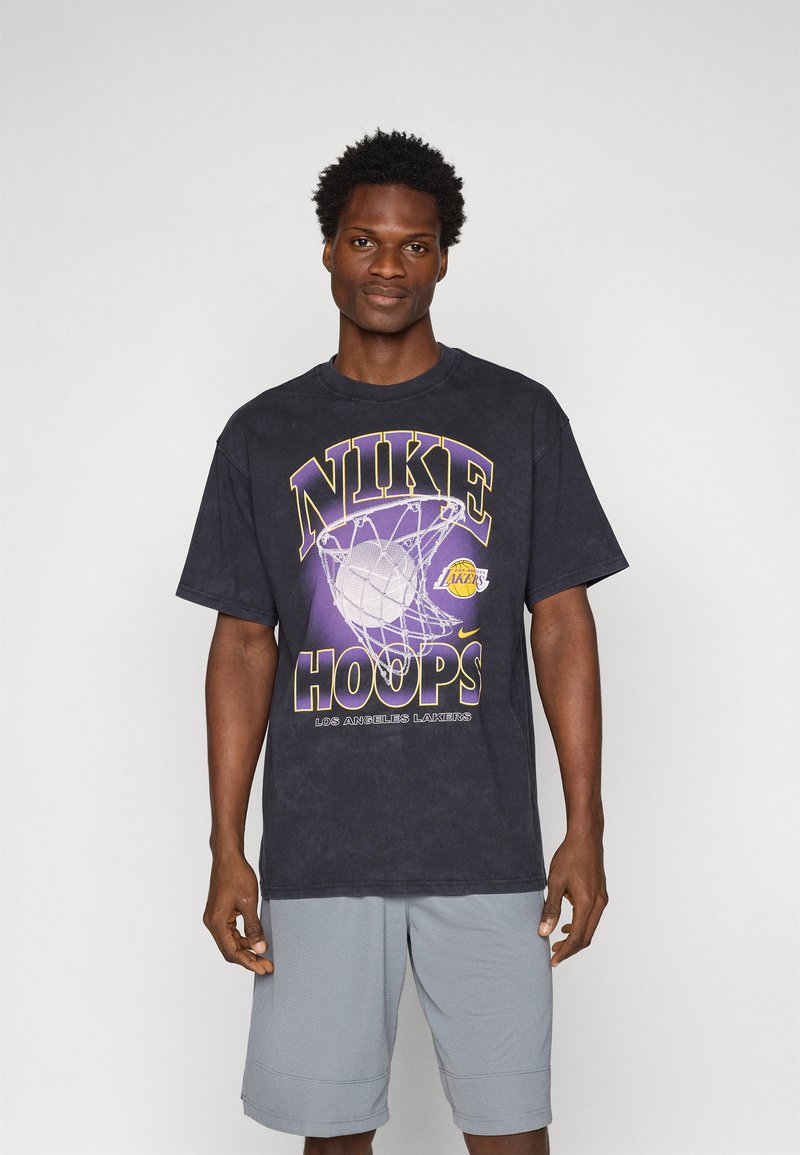 Čierne bavlnené tričko s grafikou "NIKE HOOPS" v žltej a fialovej farbe, dizajn s basketbalovou sieťou, s voľným strihom a krátkymi rukávmi.