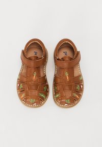 Sandales en cuir brun avec un design découpé, ornées de motifs de carottes et de légumes brodés, et d'une fermeture à bande velcro.