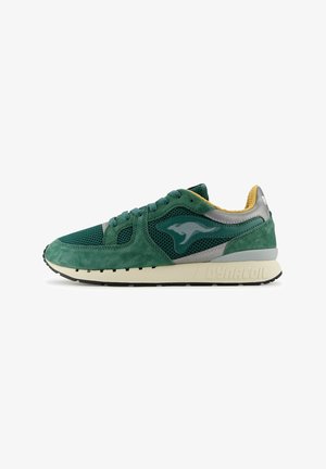 Groene suède en mesh sneaker met grijze accenten, ronde neus, vetersluiting, gevoerde kraag en witte rubberen zool met "DYNACOIL" branding.