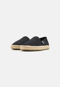 Crne platnene espadrile s potplatom od jute užeta, s dizajnom za jednostavno obuvanje i suptilnim detaljima šivanja po gornjem dijelu.