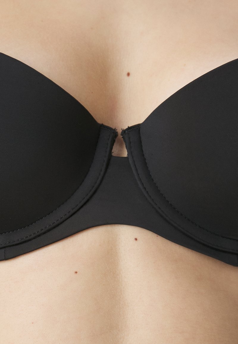 Schwarzer BH mit glattem Stoff, Bügelunterstützung und einem zentralen Ausschnitt. Verfügt über ein nahtloses Design mit robuster Naht.
