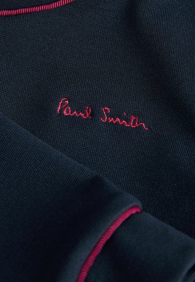Pullover blu navy con finitura testurizzata, dotato di un colletto a coste in contrasto rosa e del logo ricamato "Paul Smith" in filo rosa.