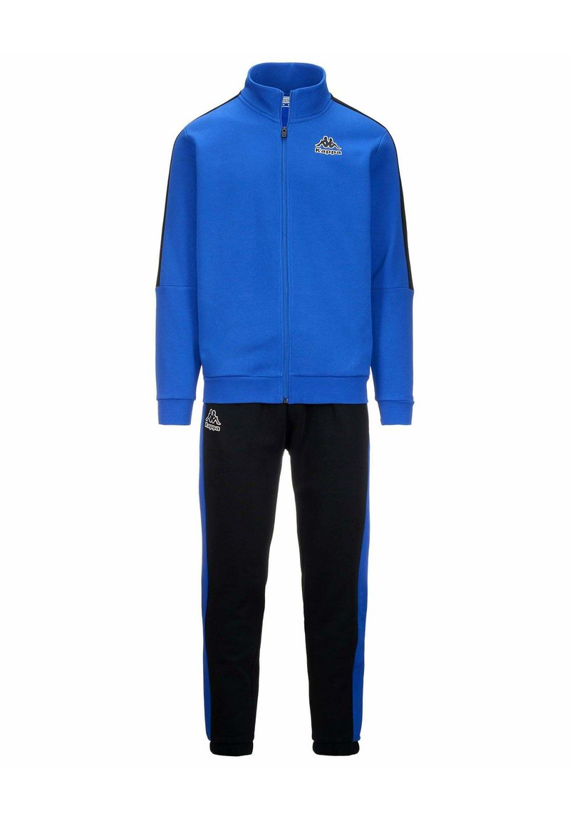 Sudadera azul con cremallera y detalles en negro, combinada con pantalones deportivos negros que tienen franjas laterales azules. Hecha de un tejido suave y texturizado.