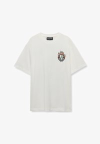 Camiseta blanca de algodón con mangas cortas, que presenta un diseño gráfico de llamas y un globo en el área del pecho izquierdo. Cuello redondo.