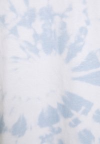 Svetle modrý tie-dye vzor na bílé látce, s jemnou bavlněnou texturou a kruhovými a radiálními designy po celém povrchu.