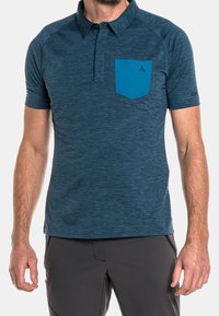 Kortärmad polo-tröja i mörkblått, tillverkad av strukturerat material. Har en kontrasterande blå bröstficka och en standard kragdesign.