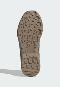 Λαστιχένια σόλα παπουτσιού με επιθετικό σχέδιο πέλματος, που διαθέτει εξαγωνικούς και γωνιώδεις προεξοχές σε ανοιχτό καφέ χρώμα για πρόσφυση και κράτημα.