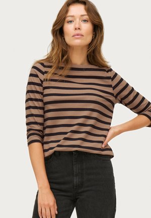 Brown and navy striped long-sleeve shirt with a crew neckline, soft fabric, and a relaxed fit, paired with high-waisted black jeans.