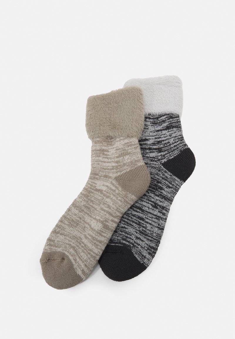 To sæt sokker: det ene i beige med en plyschkant og stribet design, det andet i grå med et struktureret mønster og sort tå.
