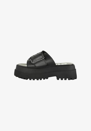 Black platform slide sandal with thick sole, adjustable buckle strap embossed with "BUFFALO" branding.
