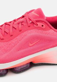 Nike löparsko i klar rosa tyg, med texturerad mesh och mjuka detaljer, samt synlig Air Zoom dämpning i en semi-transparent sula.
