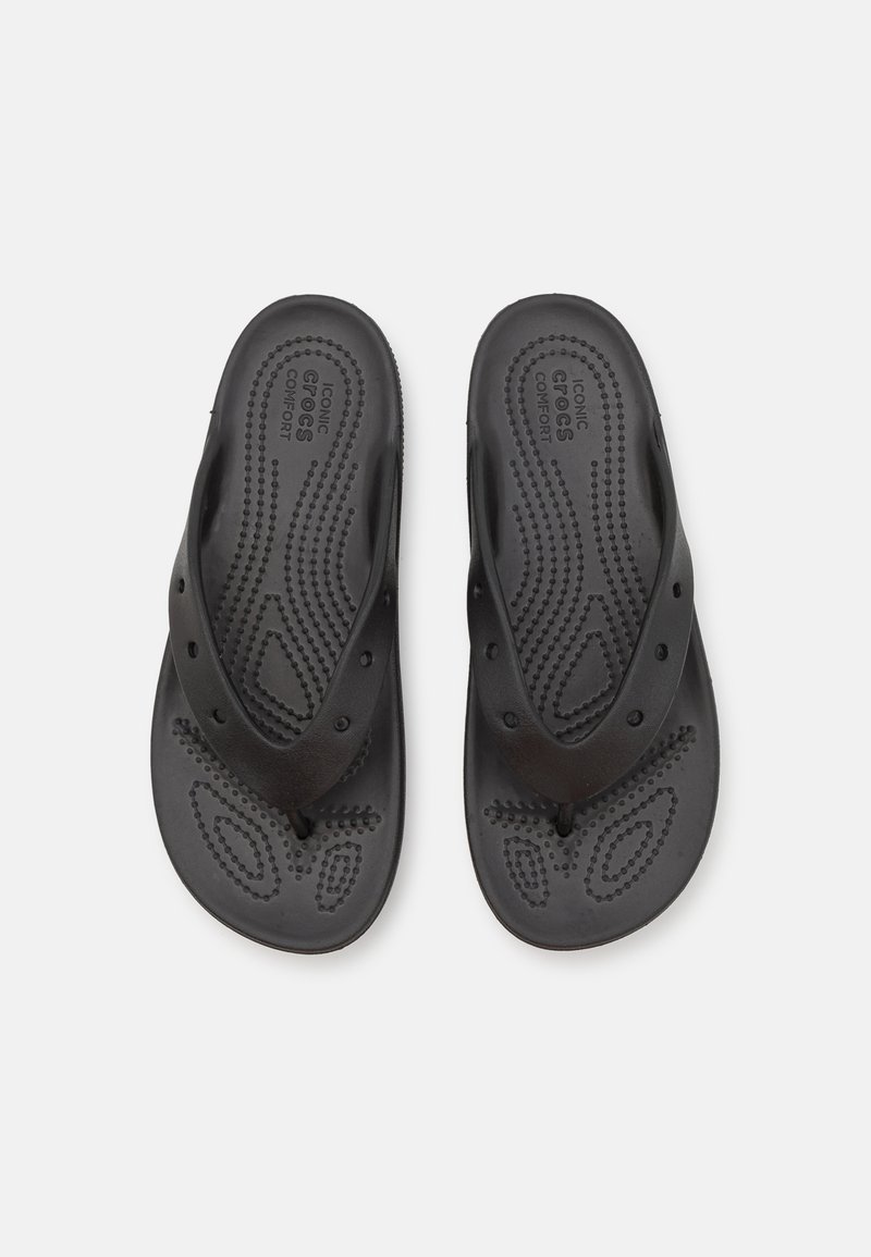 Chanclas negras de goma con una base texturizada, puntos elevados para mayor agarre y tiras estrechas en forma de V.