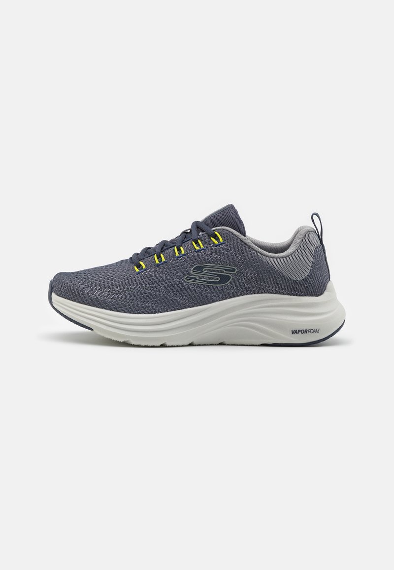 Sneaker in rete blu arioso con accenti gialli, suola VaporFoam bianca imbottita, punta arrotondata e suola sintetica per grip e supporto.